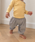 Yellow and periwinkle striped Pickle baby balloon pants with gathered ankles, back view